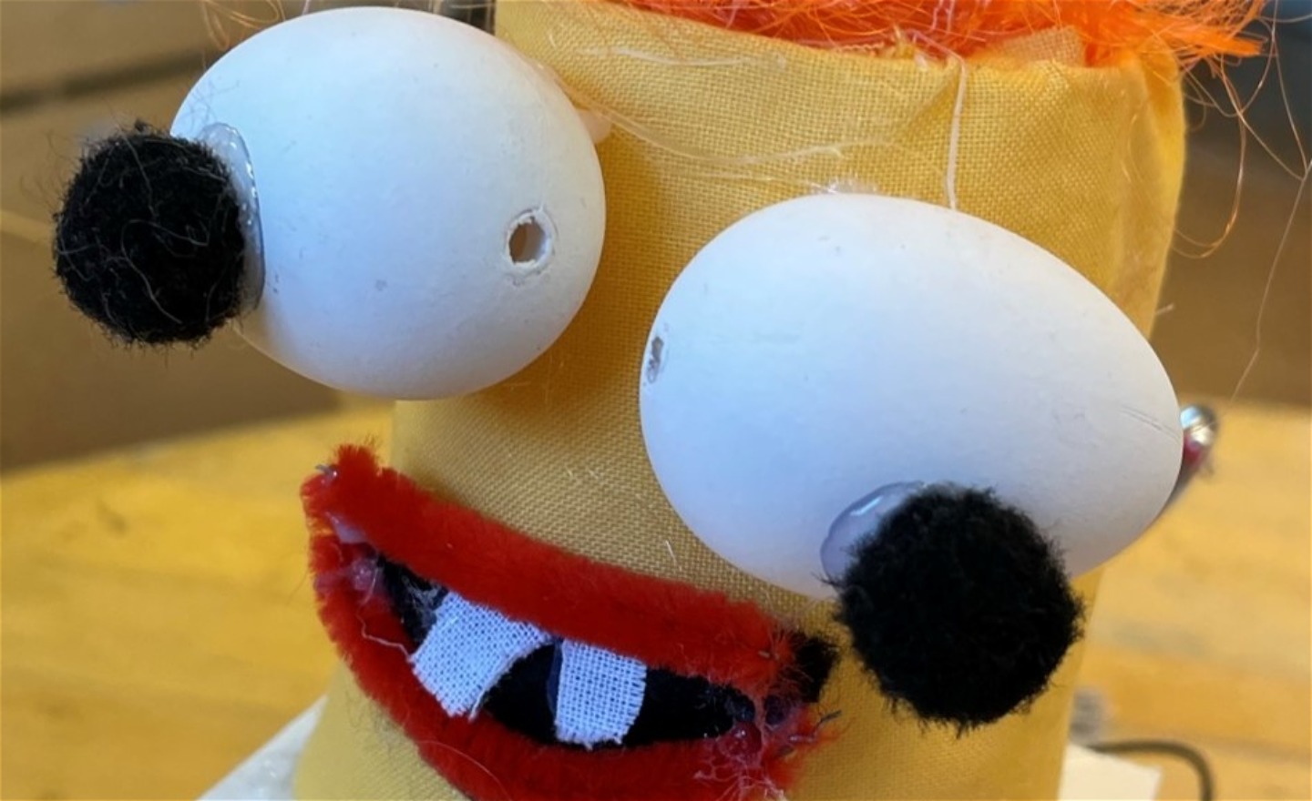 Robot med bara två tänder och med  ögon gjorda av ägg med pompompupiller.