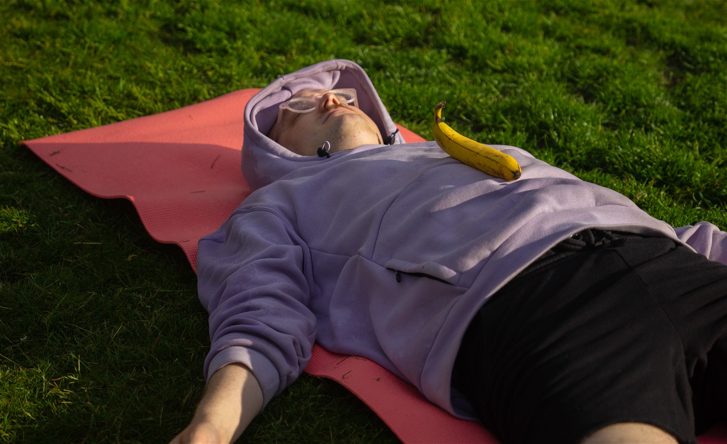 En person ligger på marken på en matta och slappnar av
