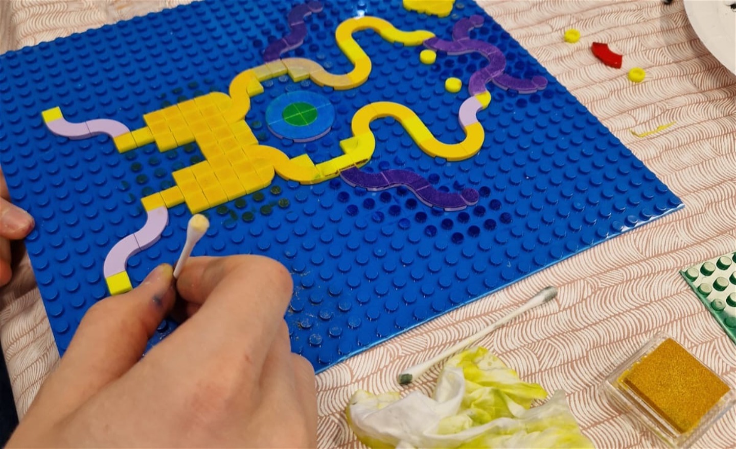 en hand som visar färgning från stämpeldynor på legot 