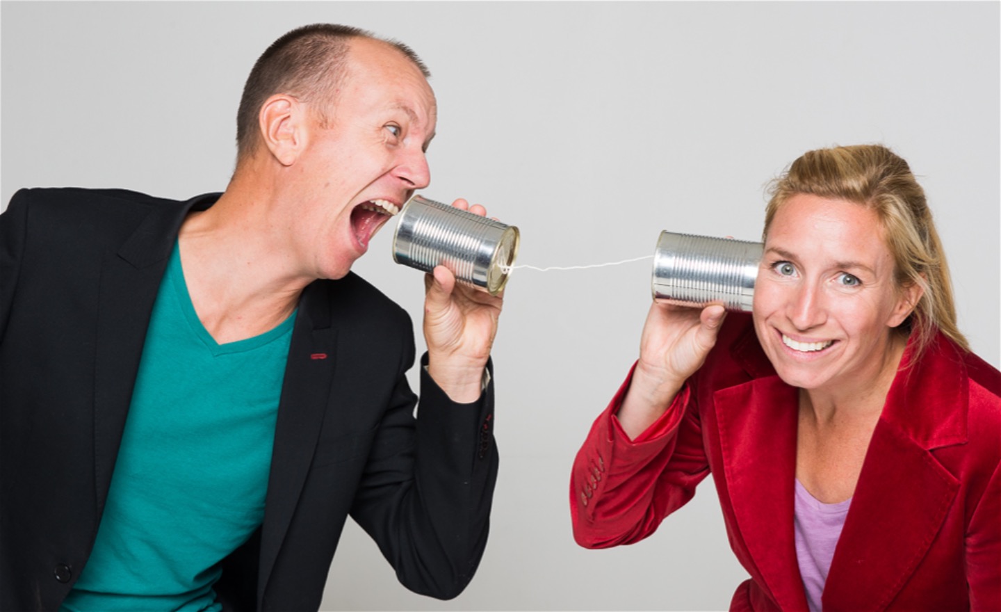 En person ropar till en annan. De kommunicerar genom två konservburkar sammanbundna med ett snöre.