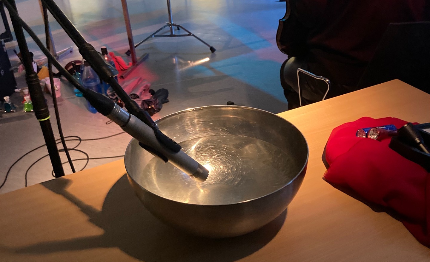 En mikrofon är riktad mot en vattenfylld metallskål 
