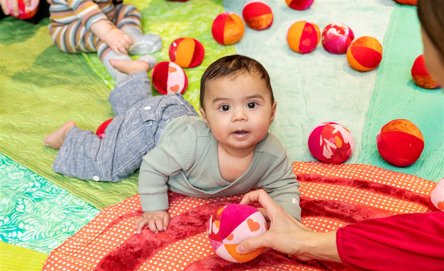 Bebis leker med plingbollar i ett babygym