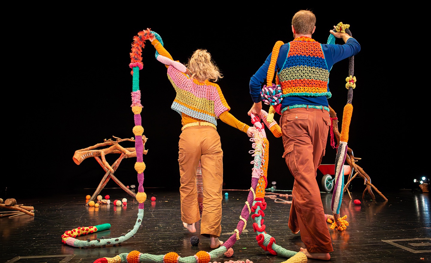 anna och Oskar, två dansare, går bald virkade ormar och nystan på scenen