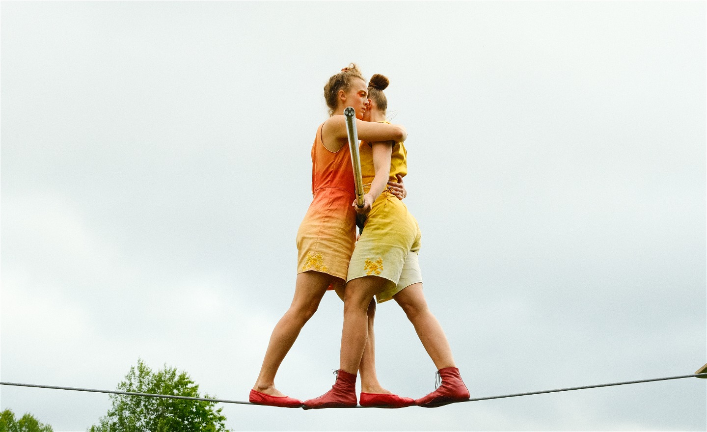 två kvinnor balanserar på en lina tillsammans. 