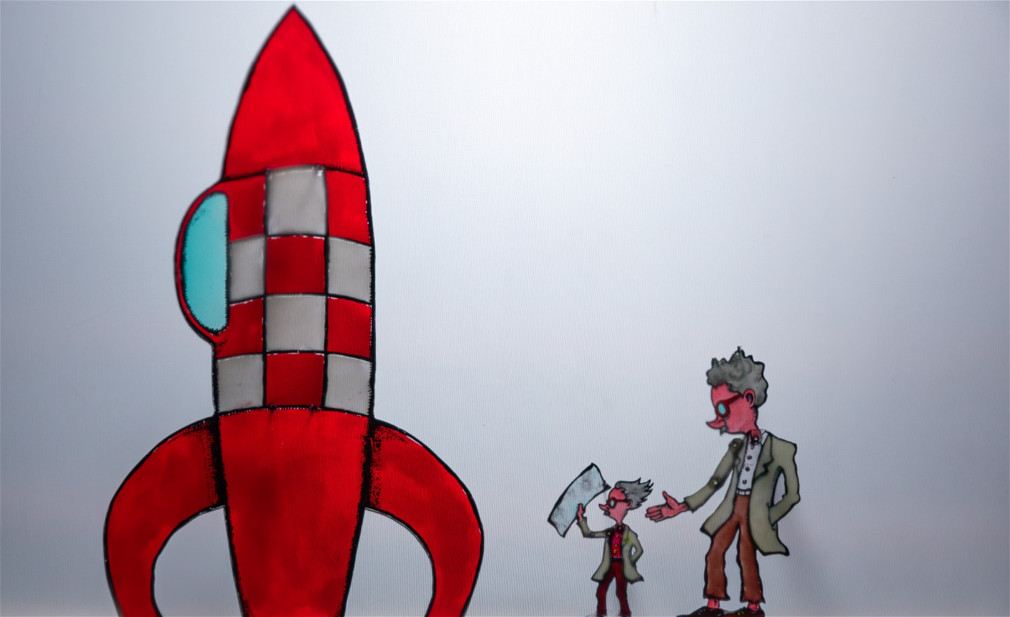 Färgskuggspel: Albert och Einstein på väg att borda raketen som ska ta dom till den punkt där papperslappen dom har med sig inte längre påverkas av tyngdkraften.