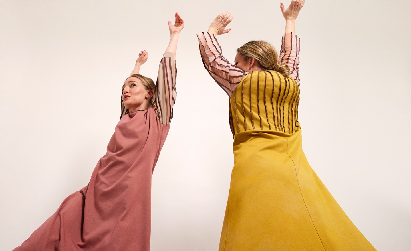 två dansare i gul och rosa klänning. bild tagen underifrån