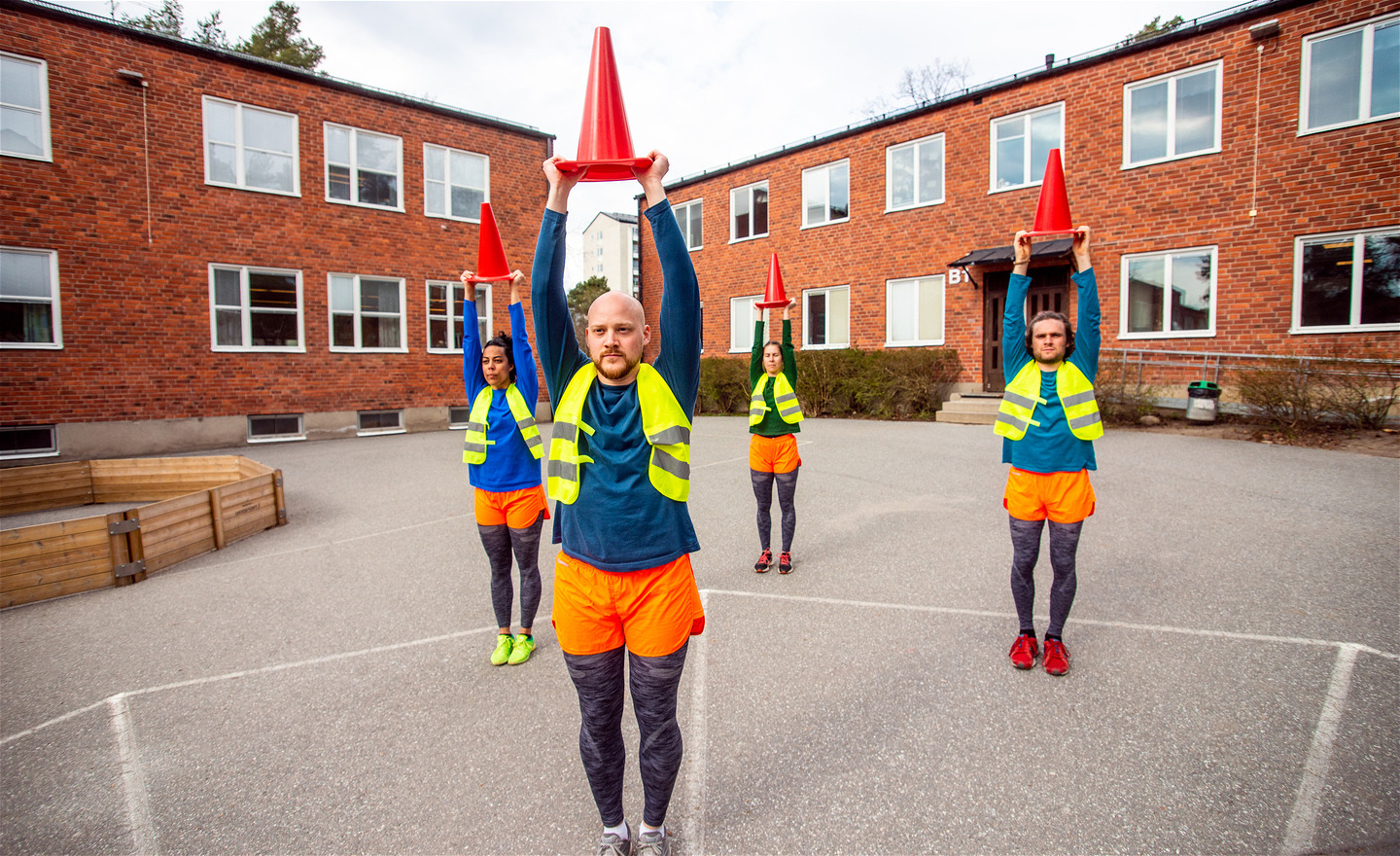 4 dansare håller trafikkoner över huvudet