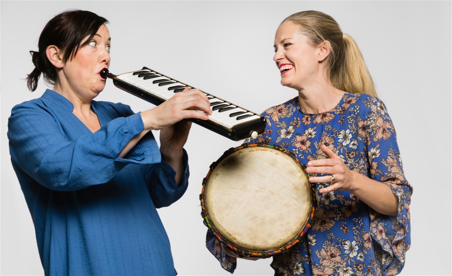 Två musiker från Musikkraft spelar melodica och djembe och ser glada ut