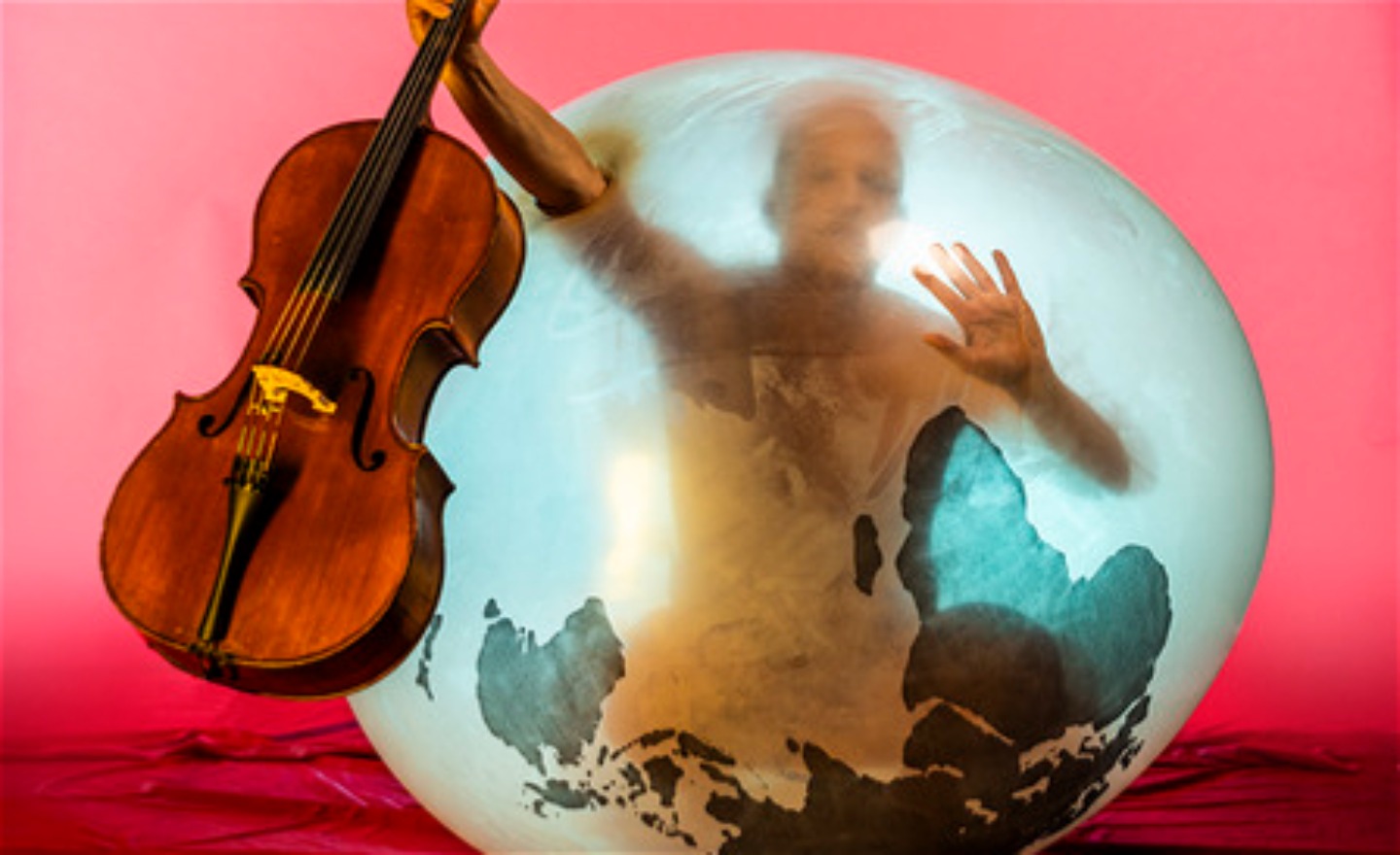 En man i en ballong med cello utanför ballongen