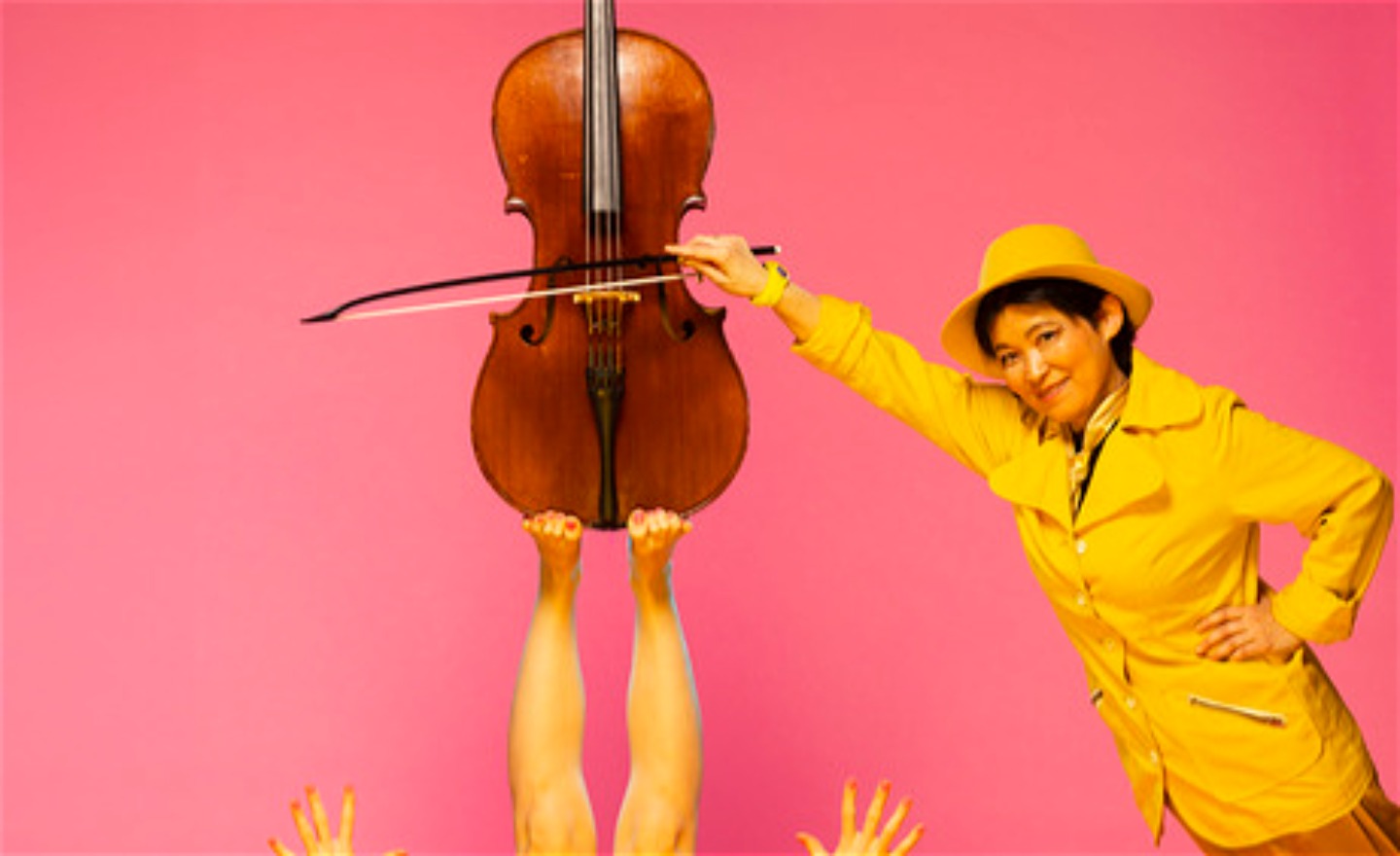En cello på fötter med cellist i gula kläder