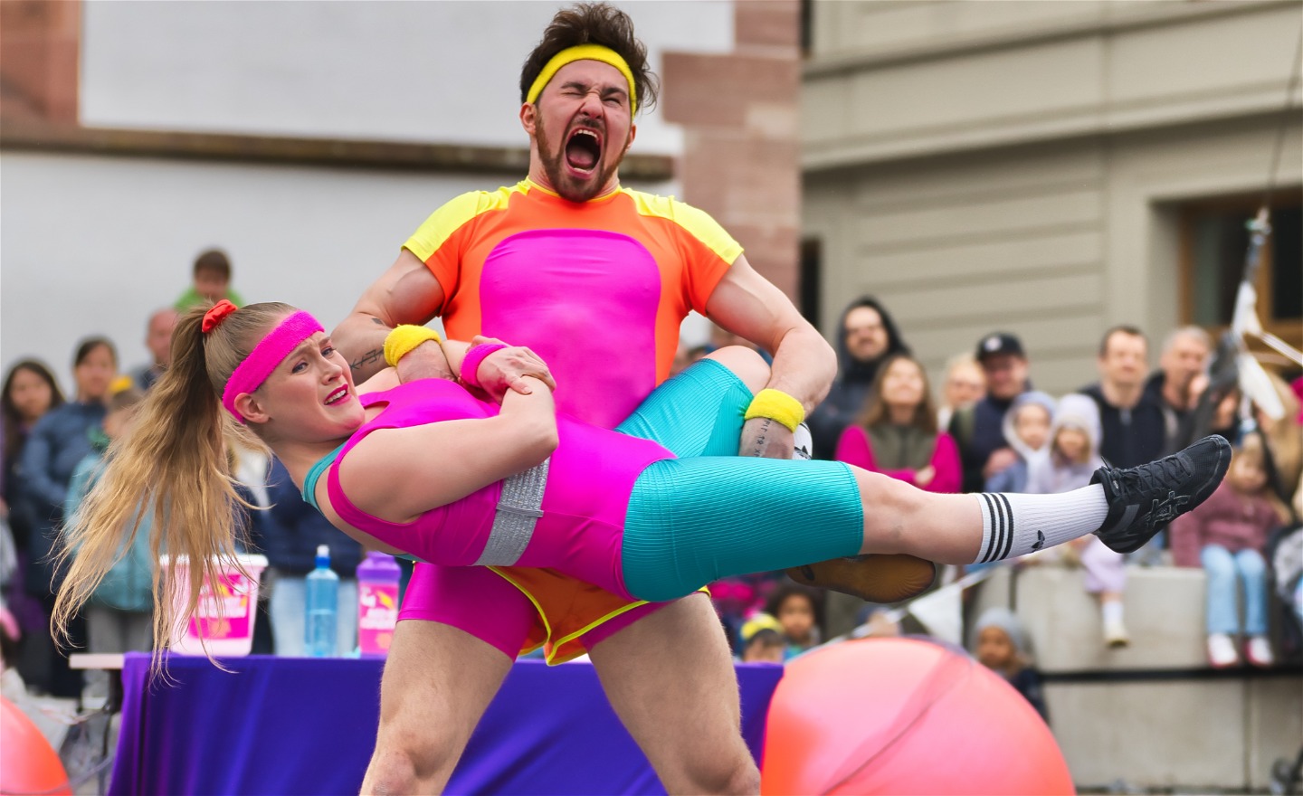 Två cirkusartister i färgglada kläder.