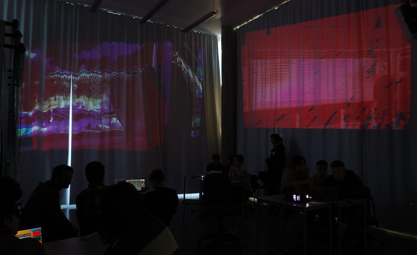 Pågående workshop i ett klassrum med elever, videoprojektioner på väggarna