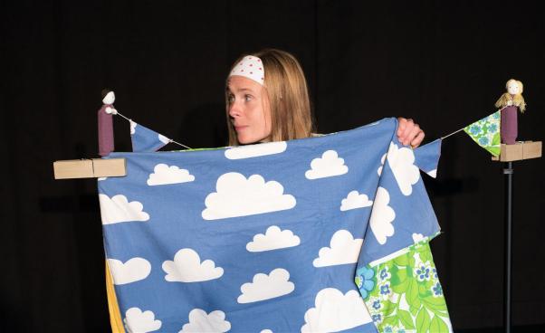 Micaela sätter upp blå filt med moln på ett klädsträck
