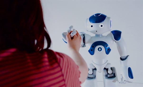 En robot som håller en flicka i handen.